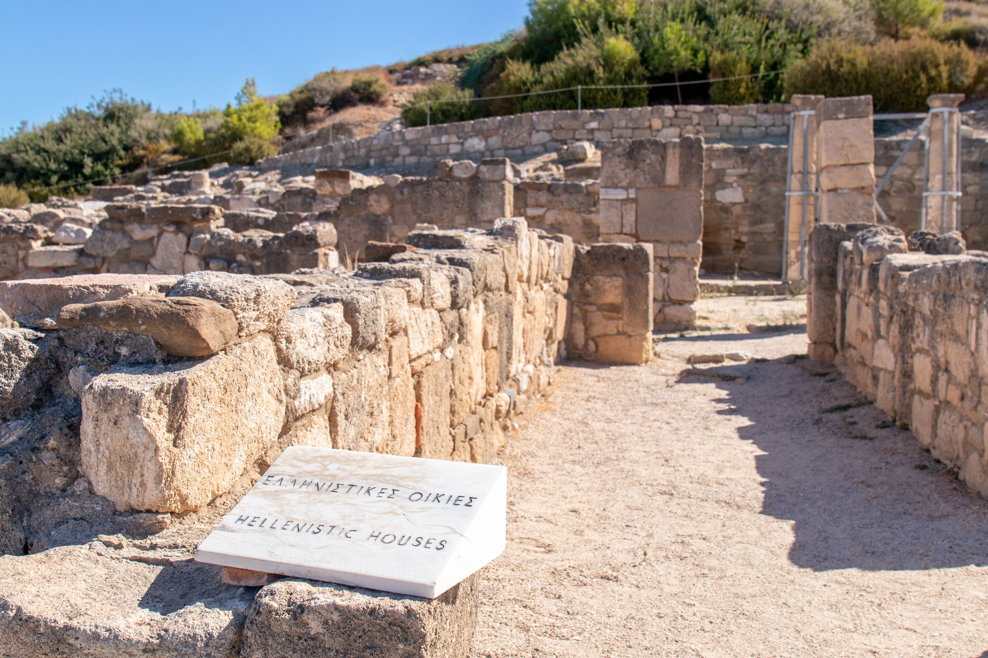 Central residential street of Ancient Kamiros lined with stone house foundations in Rhodes