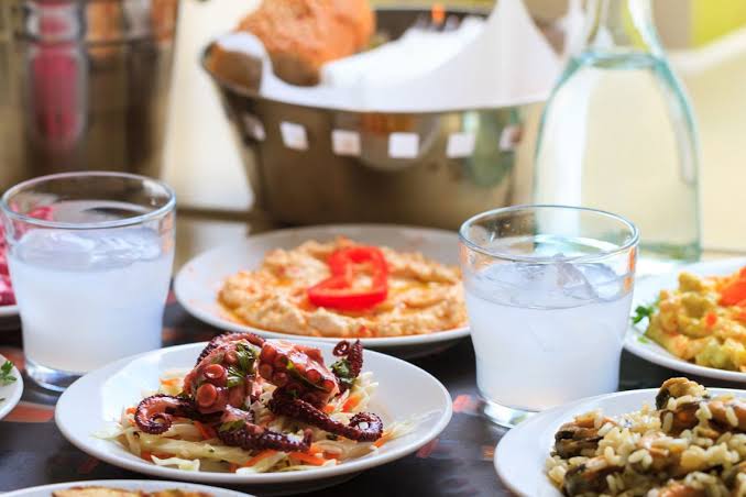Traditional Rhodian meze spread with fritters, seafood and salads on a taverna table